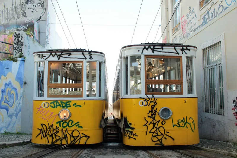 Classic yellow trams on a cobbled street in Lisbon